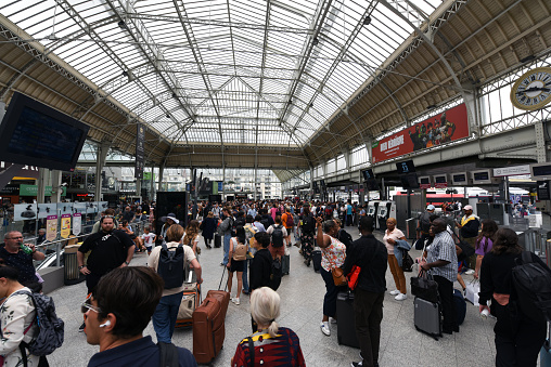 The Gare de Lyon is one of the six large mainline railway station termini in Paris, France. It handles about 90,000,000 passengers every year, making it the third busiest station of France. The station was built for the World Exposition of 1900. The image shows the building interior with a lot of people gettingt their connections.