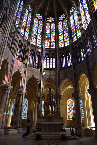 The Basilica of Saint-Denisis a large former medieval abbey church and present cathedral in the commune of Saint-Denis, a northern suburb of Paris. The church was completed in 1144 and widely considered the first structure to employ all of the elements of Gothic architecture. The image shows the interior of that magnificant cathedral with the wonderful stained glass windows.