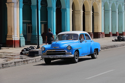 Havana, Cuba-October 8, 2019: Blue-white old American classic car -almendron, yank tank- Chevrolet Styleline DeLuxe 4-door Sedan 1952 drives the Paseo del Prado promenade southernmost end, east side.