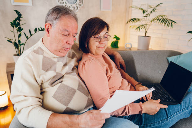 istock Couple looking at the bills at home 2114457146