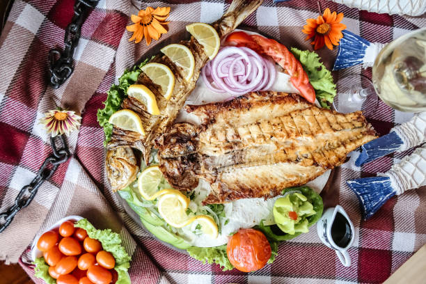 istock Platter of Grilled Fish and Vegetables on a Picnic Blanket 2114473349
