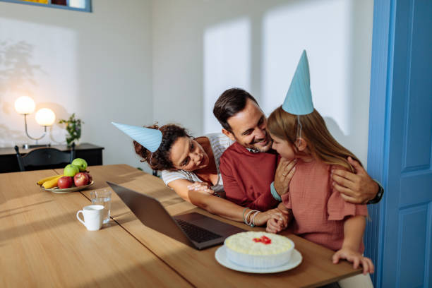 istock Family at the dining table with a cake celebrating birthday 2114497835