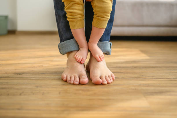 Father and baby bare feet on floor