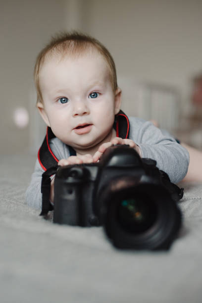 istock Little boy photographer lying with camera 2114581135