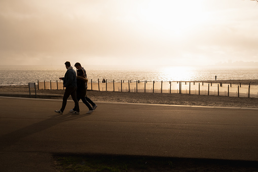 Saint Nazaire, France – February 03, 2024: The people stroll along the oceanfront during a beautiful sunset