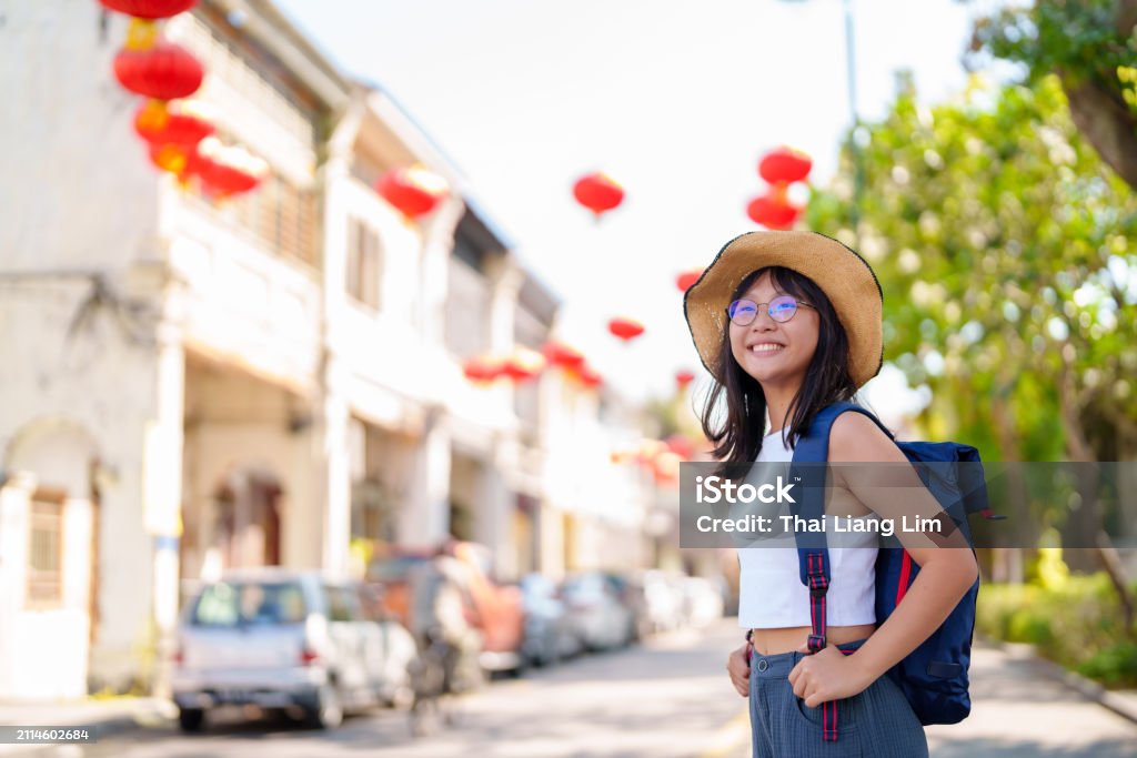 A cheerful and young Asian teenager girl traveler, with a backpack and straw hat exploring Georgetown, Penang. - Royalty-free Turista Foto de stock A cheerful and young Asian teenager girl traveler, with a backpack and straw hat exploring Georgetown, Penang. - Royalty-free Turista Foto de stock