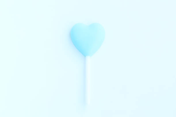A single blue raspberry jolly rancher in front of an orange texture.