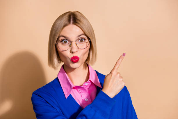 istock Photo of nice impressed person pouted lips direct finger empty space information isolated on beige color background 2114629287