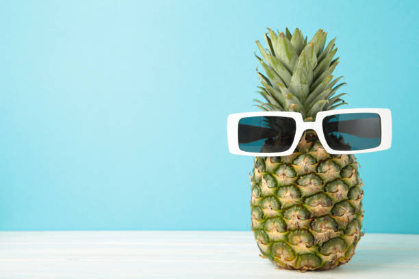 istock Ripe pineapple with sunglasses on blue background. Space for text 2114632960