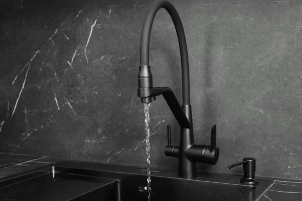 istock Faucet and flowing water, black modern minimalist kitchen interior 2114659892