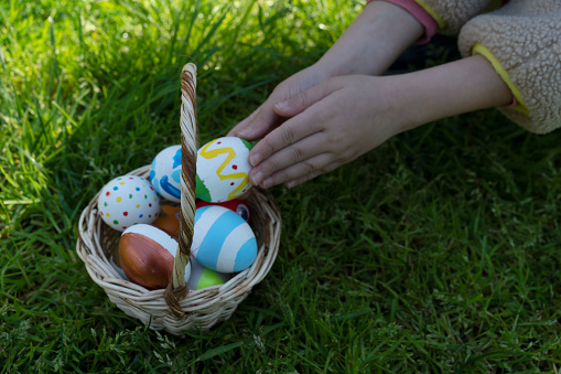 Colorful Easter eggs in little girls hand.Kids hunt for egg outdoors