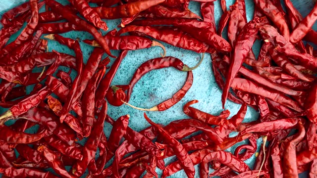 Dried chili peppers on a blue ceramic bowl.