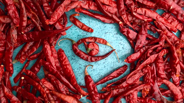 Dried chili peppers on a blue ceramic bowl.