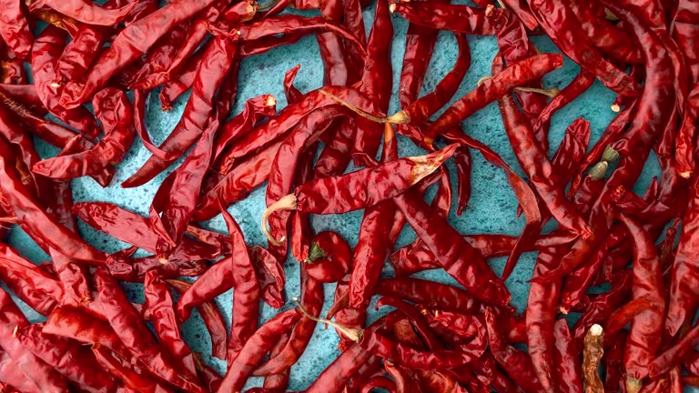 Dried chili peppers on a blue ceramic bowl.