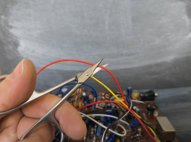 istock Cut the red wire with scissors, concept of choice. 2114679702