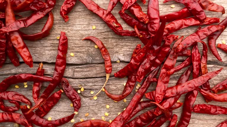 Dried chili peppers on an old weathered wood background.