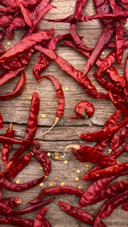 Dried chili peppers on an old weathered wood background.