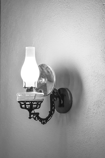 An antique lantern hangs on the wall. A symbol of times gone by.