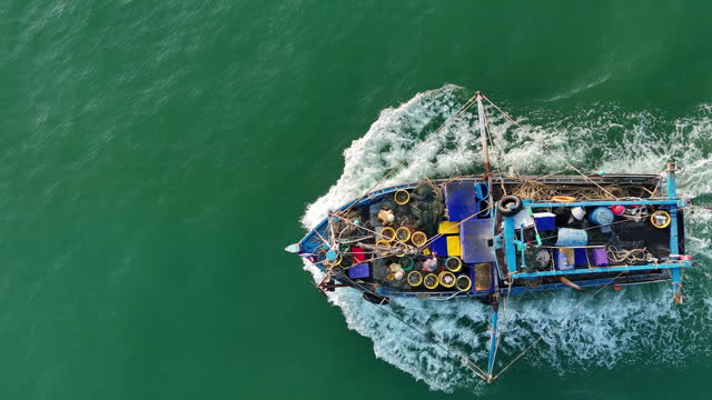 Fishing boat running  go to the ocean for boatman catching fish all a long night - at Thailand. Top view of Fishing Boat running verry fast on the sea to port.