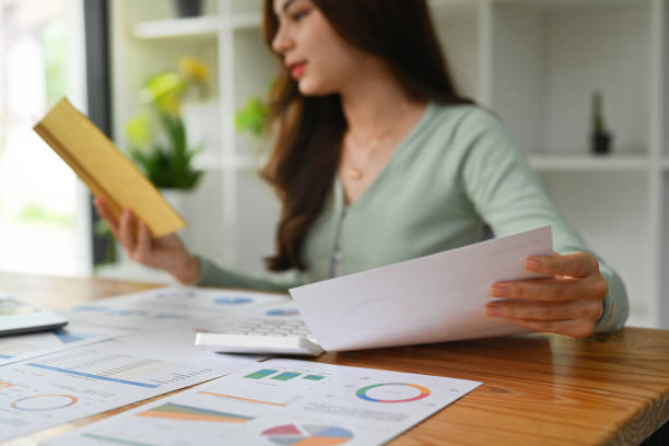 istock Selective focus on hand. Female accountant working with financial document at office desk. 2114719181