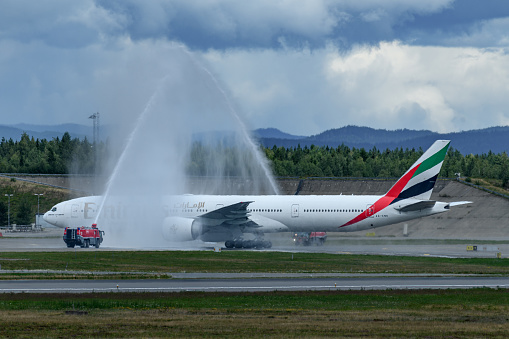 Emirates Boeing 777-300ER final landing by the captain, Oslo Airport Gardermoen. Water portal by the fire engines at the airport