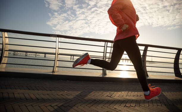 istock Fitness woman runner running on seaside bridge 2114724485