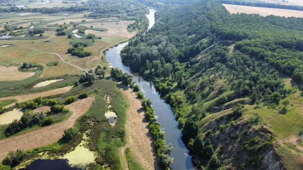 istock Drone view of a beautiful landscape with fields and a river 2114724998