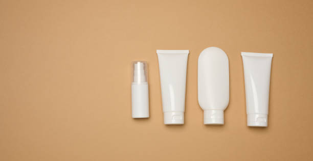 istock White plastic tubes, jars, and containers for cosmetic products on a brown background 2114730220