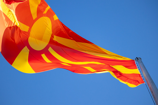 North macedonia flag waving in sunny blue sky.