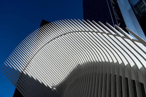 Wall Street, Manhattan, New York, USA - March, 2024. Close up of the Oculus building in Wall Street from outside the transport hub.Also known as The World Trade Center Transportation Hub. It is the Port Authority of New York and New Jersey's formal name for the new PATH station and the associated transit and retail complex that opened on March 3, 2016. It was designed by Spanish architect Santiago Calatrava and composed of a train station with a large and open mezzanine under the National September 11 Memorial plaza. This mezzanine is connected to an above ground structure called the Oculus—located between 2 World Trade Center and 3 World Trade Center—as well as to public concourses under the various towers in the World Trade Center complex.