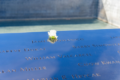 Manhattan, New York, USA - March, 2024.  World Trade Centre memorial ground zero waterfall feature.\nThe National September 11 Memorial & Museum (also known as the 9/11 Memorial & Museum) is part of the World Trade Center complex, in New York City, created for remembering the September 11 attacks of 2001. The memorial is located at the World Trade Center site, the former location of the Twin Towers that were destroyed during the September 11 attacks. The designer of the Memorial is Israeli-American architect Michael Arad of Handel Architects. Arad worked with landscape-architecture firm Peter Walker and Partners on the design to create two square reflecting pools in the center marking where the Twin Towers stood. A dedication ceremony commemorating the tenth anniversary of the attacks was held at the memorial on September 11, 2011, and it opened to the public the following day. The museum was dedicated on May 15, 2014 Six days later, the museum opened to the public.