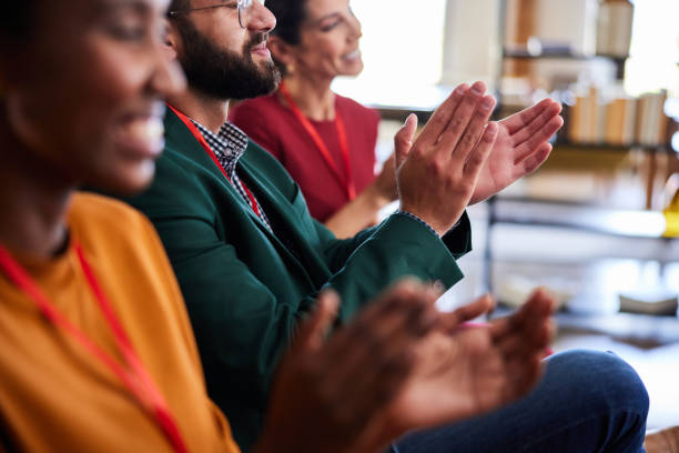 istock Group of businesspeople clapping together during a seminar in an office 2114789678