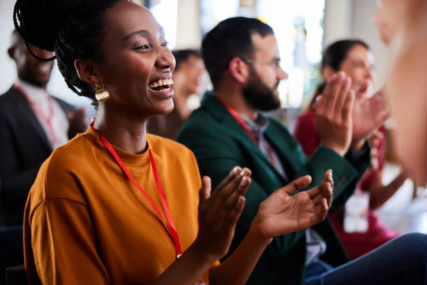 istock Laughing young businesswoman and colleagues clapping during a seminar at work 2114790719