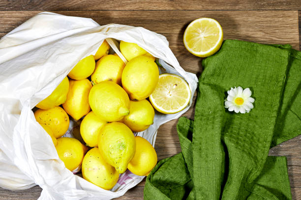 istock white plastic bag full of lemons isolated on wood table 2114820285