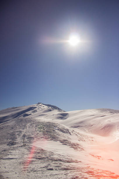 Panoramic view of snowcapped mountain range against the sun. View of the mountain range top