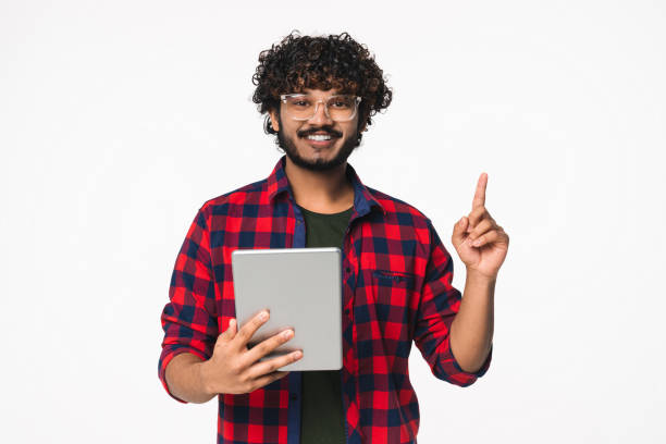 istock Cheerful young Indian freelancer having idea with digital tablet isolated over white background. 2114835584