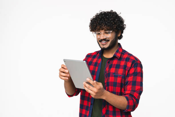 istock Happy young Indian freelancer suing digital tablet for remote job isolated over white background. 2114836106