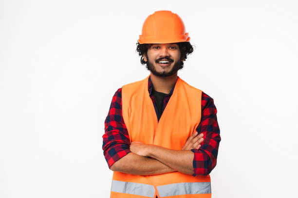 istock Cheerful young Indian construction worker in orange uniform isolated over white background. 2114838203