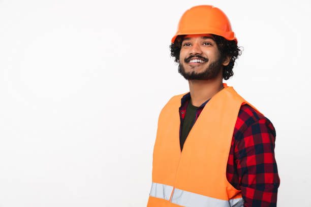 istock Cheerful young Indian constructor worker in helmet and orange uniform isolated over white background 2114839251