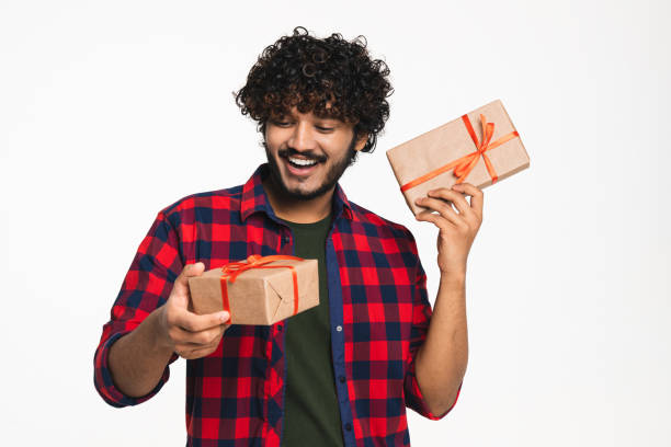 istock Happy Indian man shaking present boxes isolated over white background. 2114840848