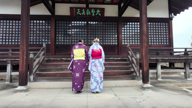 Female friends in kimono walking in shrine - part 1 of 2