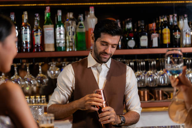istock Man bartender is making a drink and dancing at bar. Dance party with group people dancing . Women and men have fun and drinking martini cocktail in night club. 2114849893