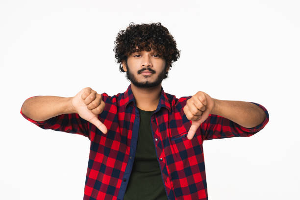 istock Sad young Hindi man showing thumbs down isolated over white background. 2114850402