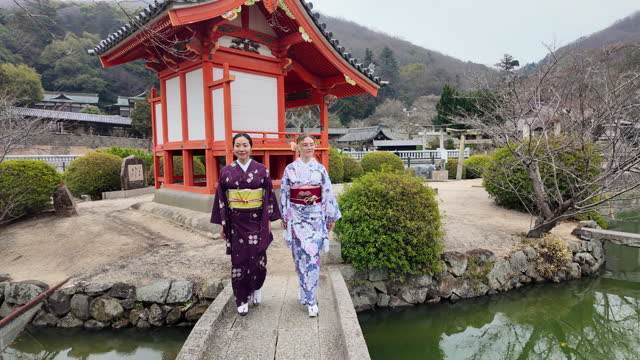 Female friends in kimono walking in shrine - part 1 of 2