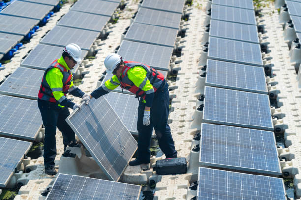 istock Male workers repair Floating solar panels on water lake. Engineers construct on site Floating solar panels at sun light. clean energy for future living. Industrial Renewable energy of green power. 2114858775