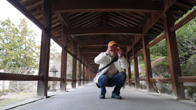 Japanese tourist walking on long corridor of shrine in the morning - part 2 of 3