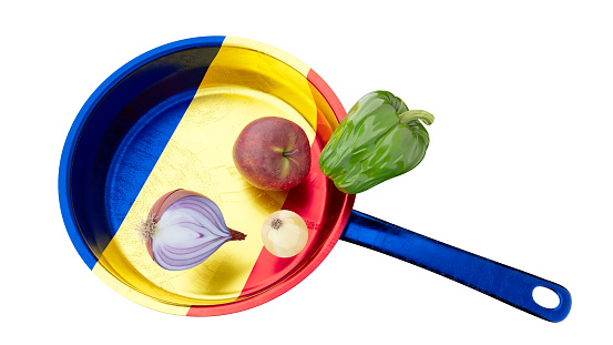 This image showcases a kitchen pan that creatively incorporates the Romanian flag's colors, adorned with a nutritious selection of an apple, onion, and bell pepper.