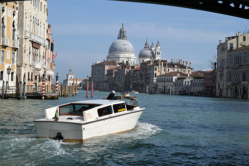 Venice, Italy, march 12, 2024 : Taxi boat on the Grand Canal with the Basilica of Santa Maria della Salute in the background