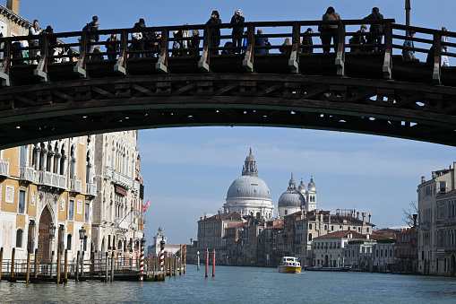 Venice, Italy, march 12, 2024 : Accademia Bridge crossing the Grand Canal with the Basilica of Santa Maria della Salute in the background