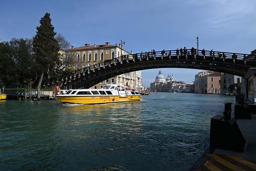 Venice, Italy, march 12, 2024 : Academy Bridge with a boat from the Alilaguna company on the Grand Canal